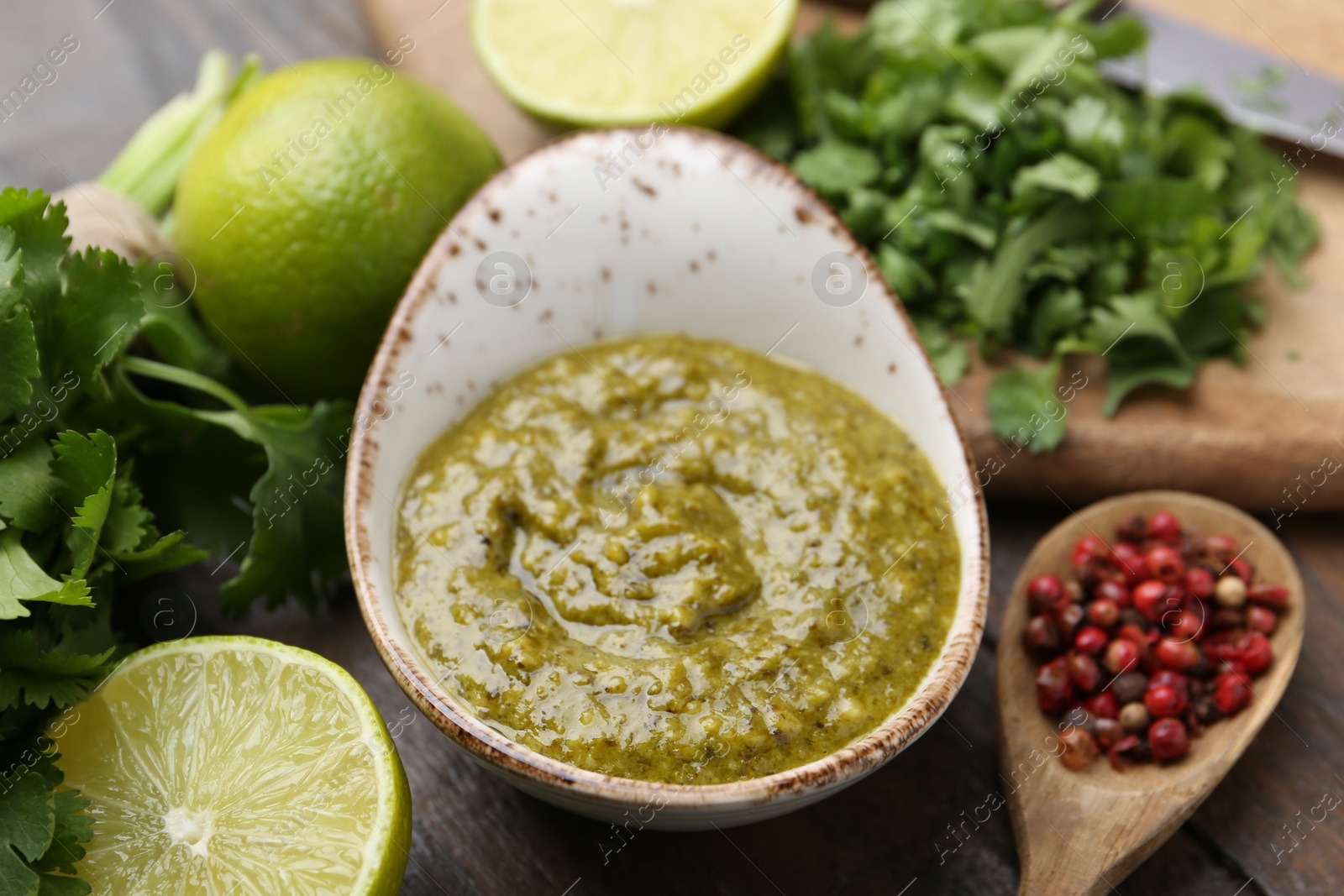 Tasty sauce with cilantro and other ingredients on wooden table, closeup Photo of Tasty sauce with cilantro and other ingredients on wooden table, closeup