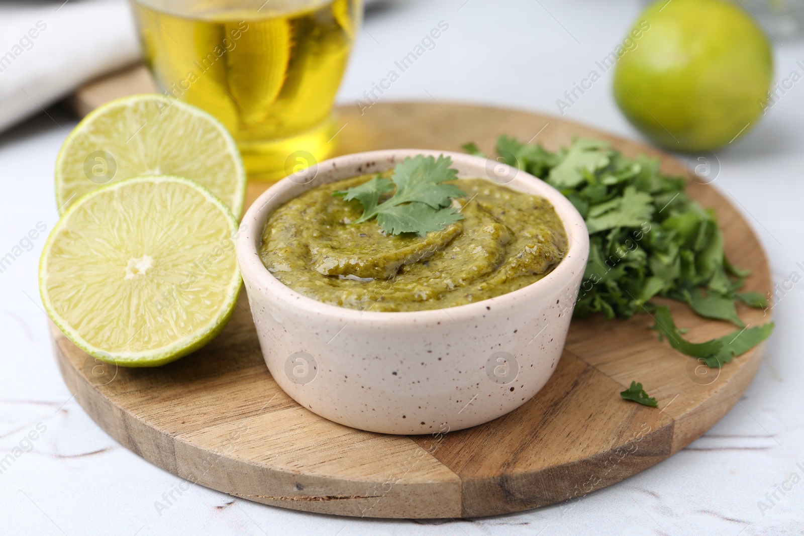 Tasty sauce with cilantro and other ingredients on white table, closeup Photo of Tasty sauce with cilantro and other ingredients on white table, closeup