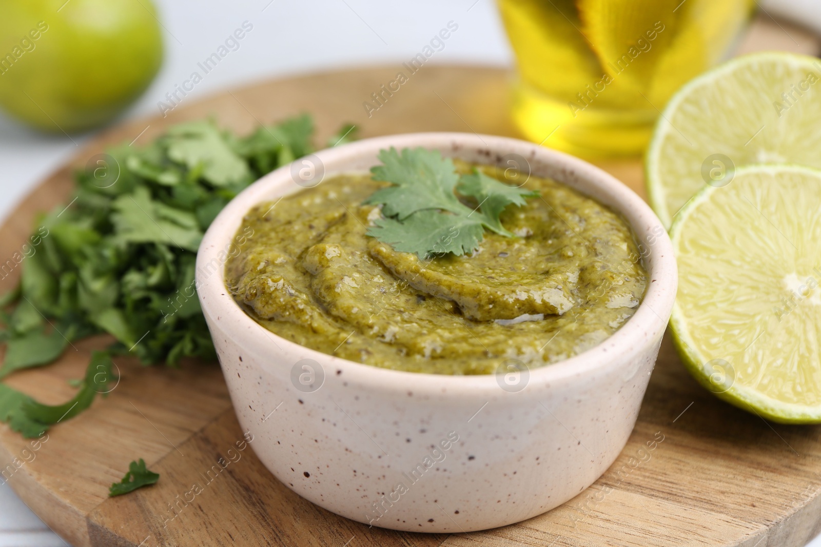 Tasty sauce with cilantro and other ingredients on table, closeup Photo of Tasty sauce with cilantro and other ingredients on table, closeup
