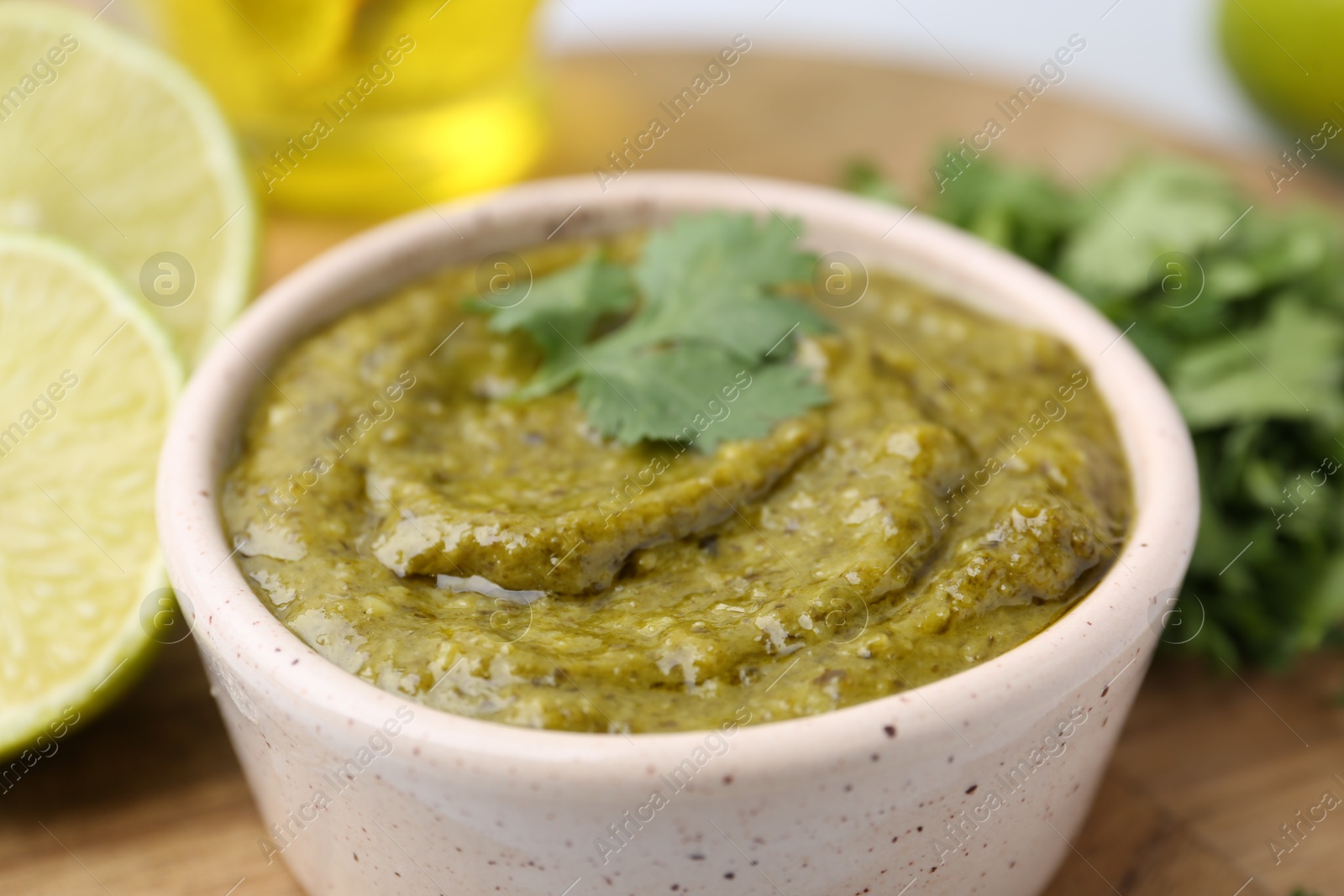 Tasty sauce with cilantro and other ingredients on table, closeup Photo of Tasty sauce with cilantro and other ingredients on table, closeup