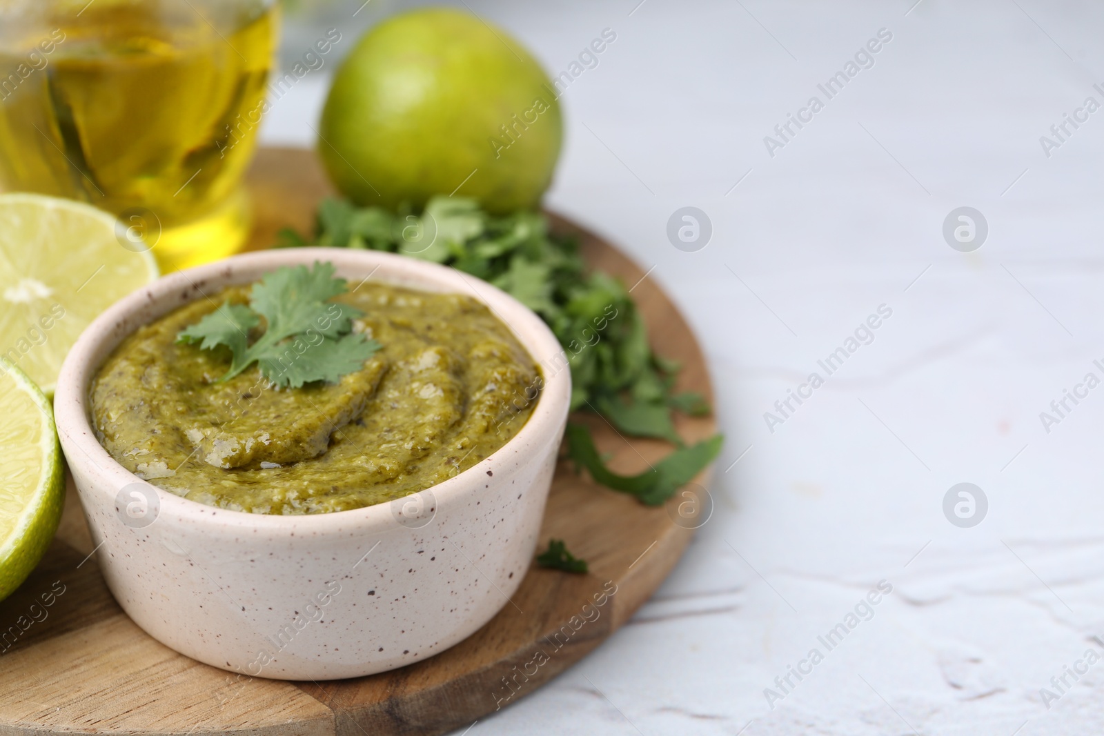 Tasty sauce with cilantro and other ingredients on white table, closeup. Space for text Photo of Tasty sauce with cilantro and other ingredients on white table, closeup. Space for text