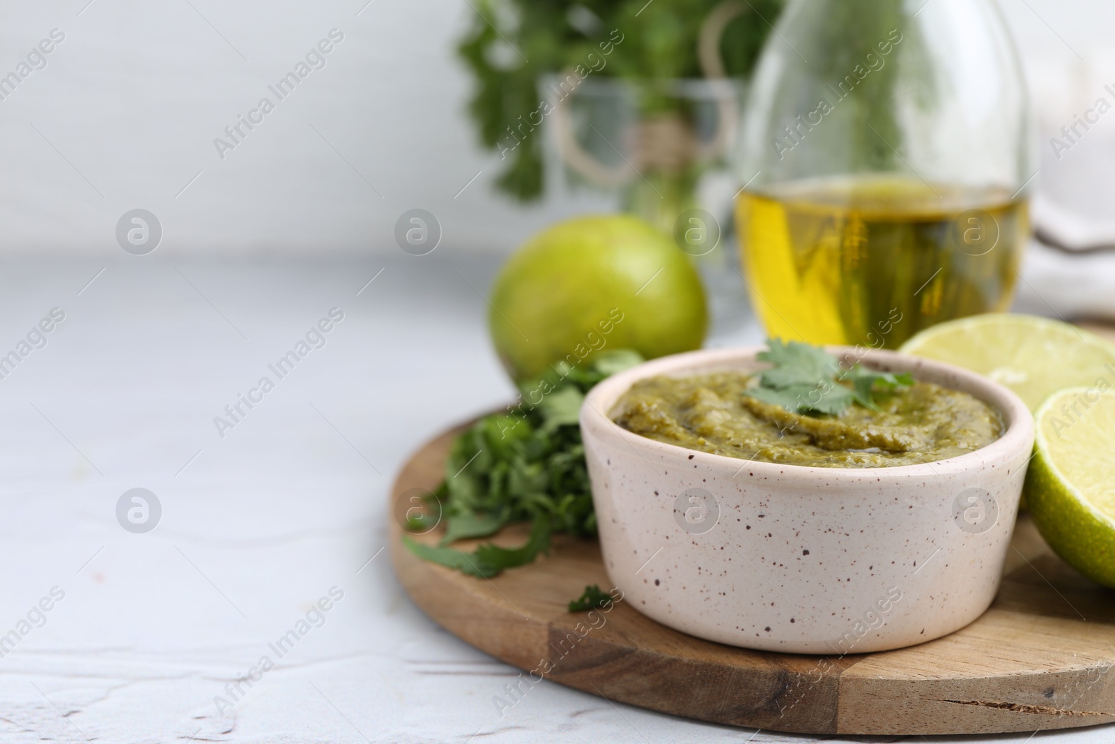 Tasty sauce with cilantro and other ingredients on white table, closeup. Space for text Photo of Tasty sauce with cilantro and other ingredients on white table, closeup. Space for text