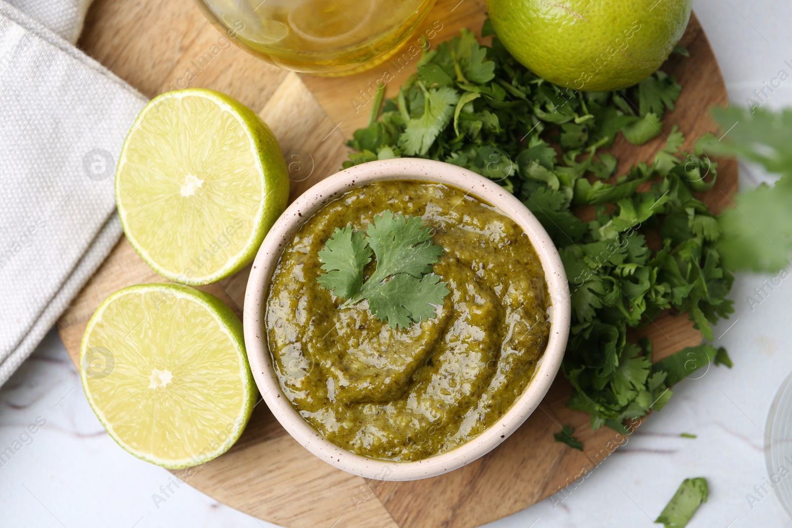 Tasty sauce with cilantro and other ingredients on white table, flat lay Photo of Tasty sauce with cilantro and other ingredients on white table, flat lay