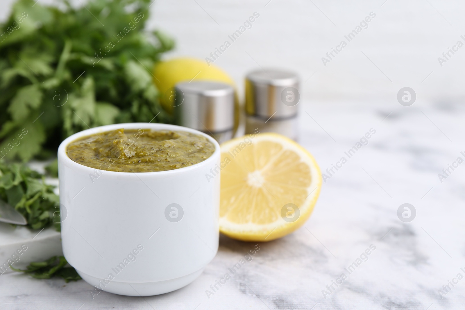 Tasty sauce with cilantro and other ingredients on white marble table, closeup. Space for text Photo of Tasty sauce with cilantro and other ingredients on white marble table, closeup. Space for text