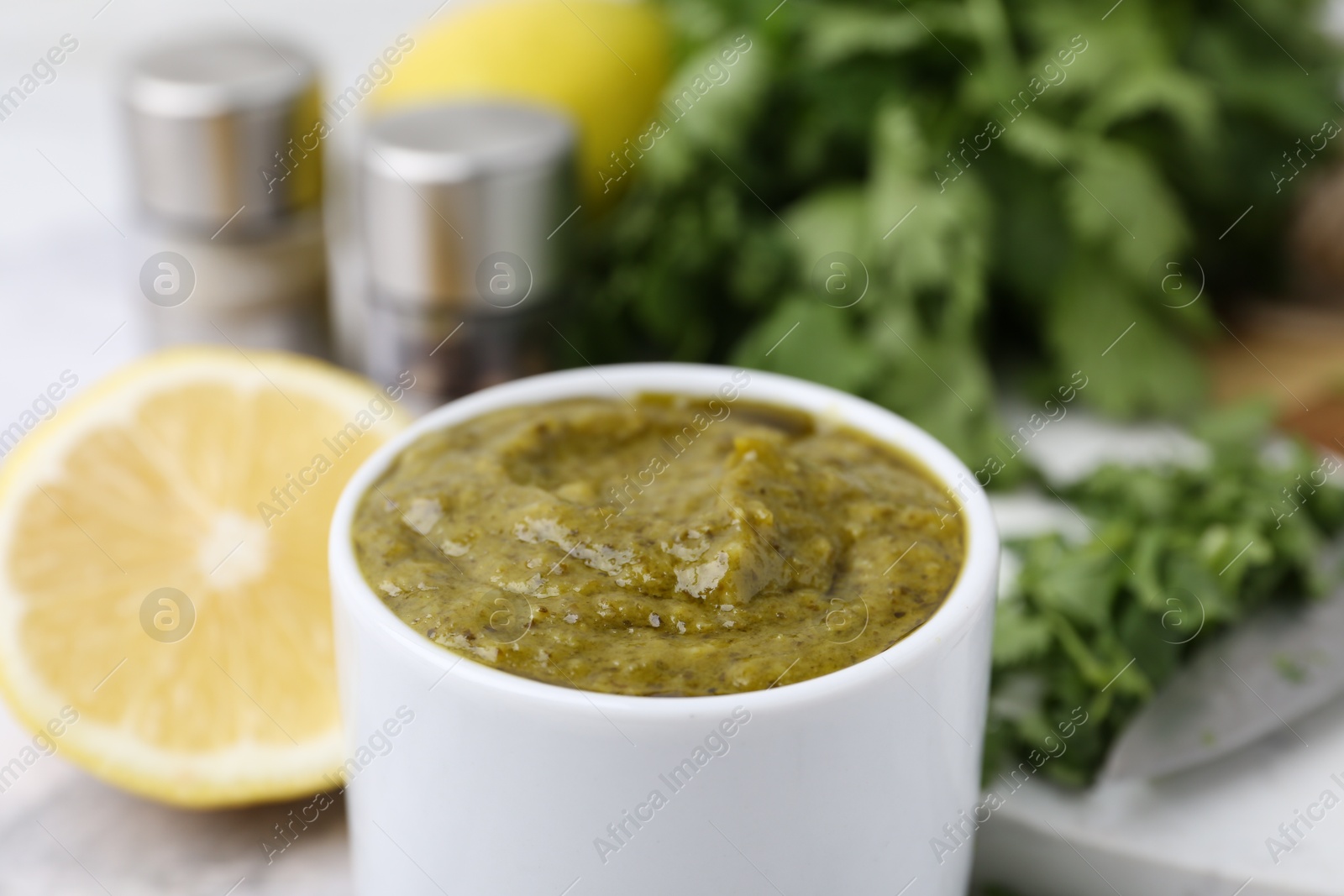 Tasty sauce with cilantro and other ingredients on table, closeup Photo of Tasty sauce with cilantro and other ingredients on table, closeup