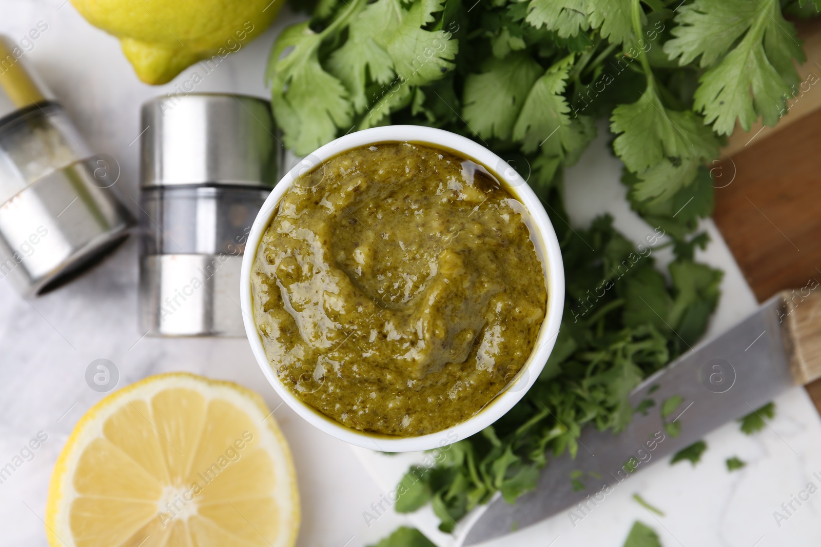 Tasty sauce with cilantro and other ingredients on white marble table, flat lay Photo of Tasty sauce with cilantro and other ingredients on white marble table, flat lay