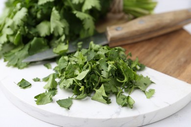 Photo of Fresh green cilantro and knife on table, closeup