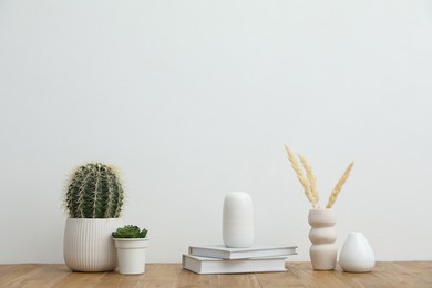 Photo of Different decor on wooden table near white wall indoors
