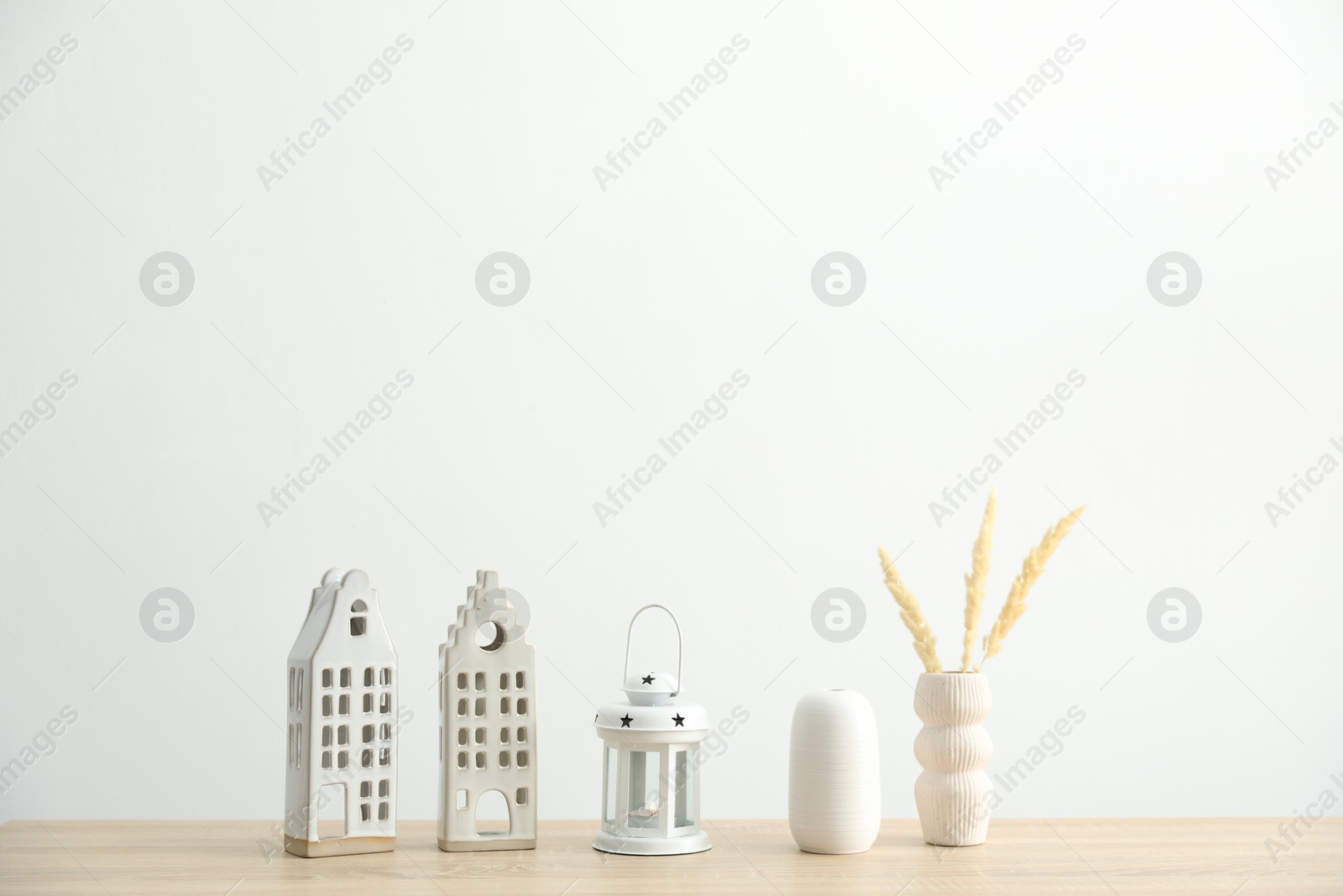 Different decor on wooden table near white wall indoors Photo of Different decor on wooden table near white wall indoors