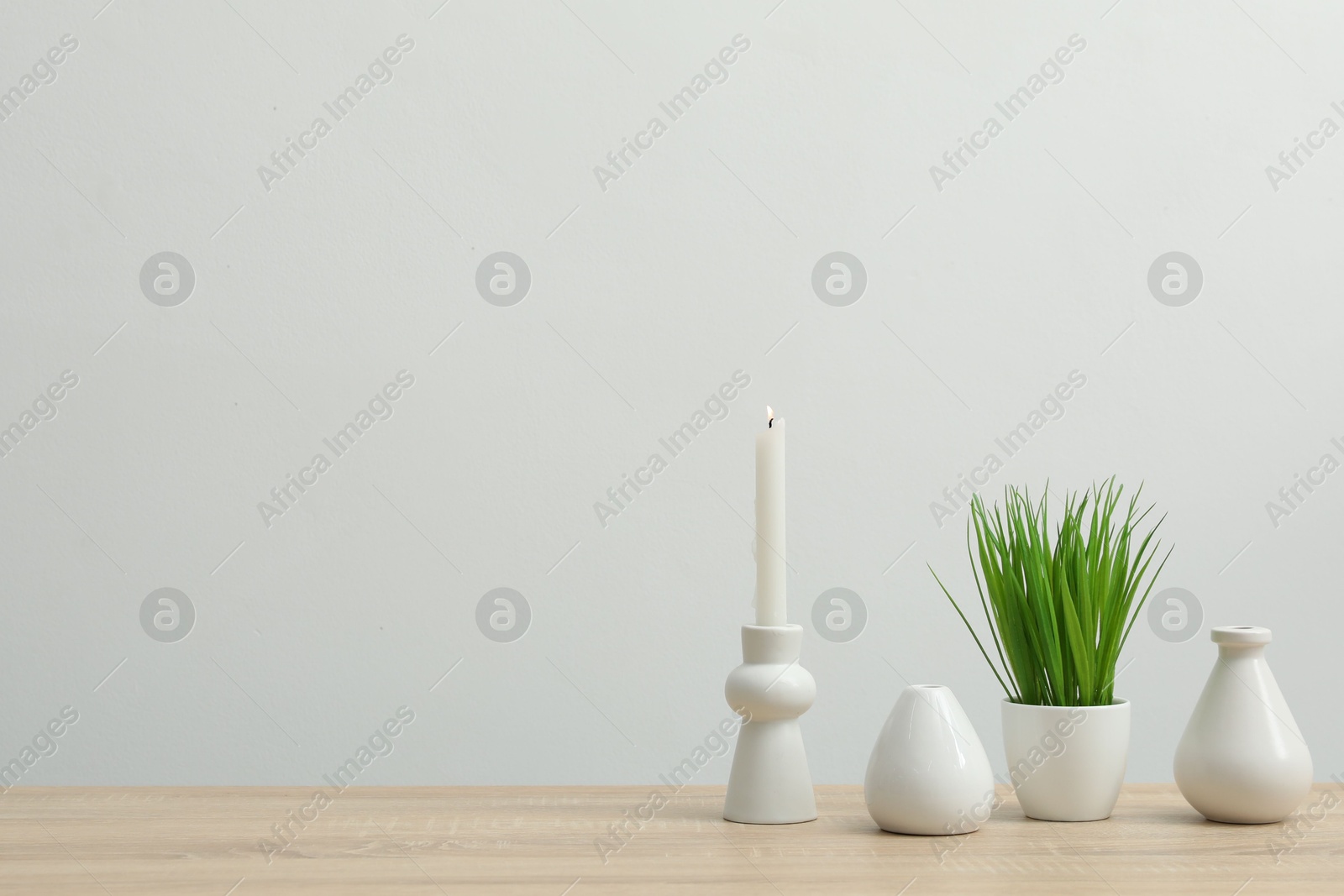 Different decor on wooden table near white wall indoors, space for text Photo of Different decor on wooden table near white wall indoors, space for text