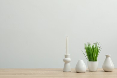 Photo of Different decor on wooden table near white wall indoors, space for text
