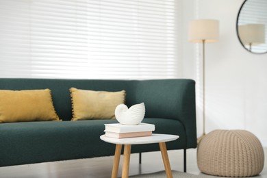 Photo of Beautiful vase and books on white table indoors