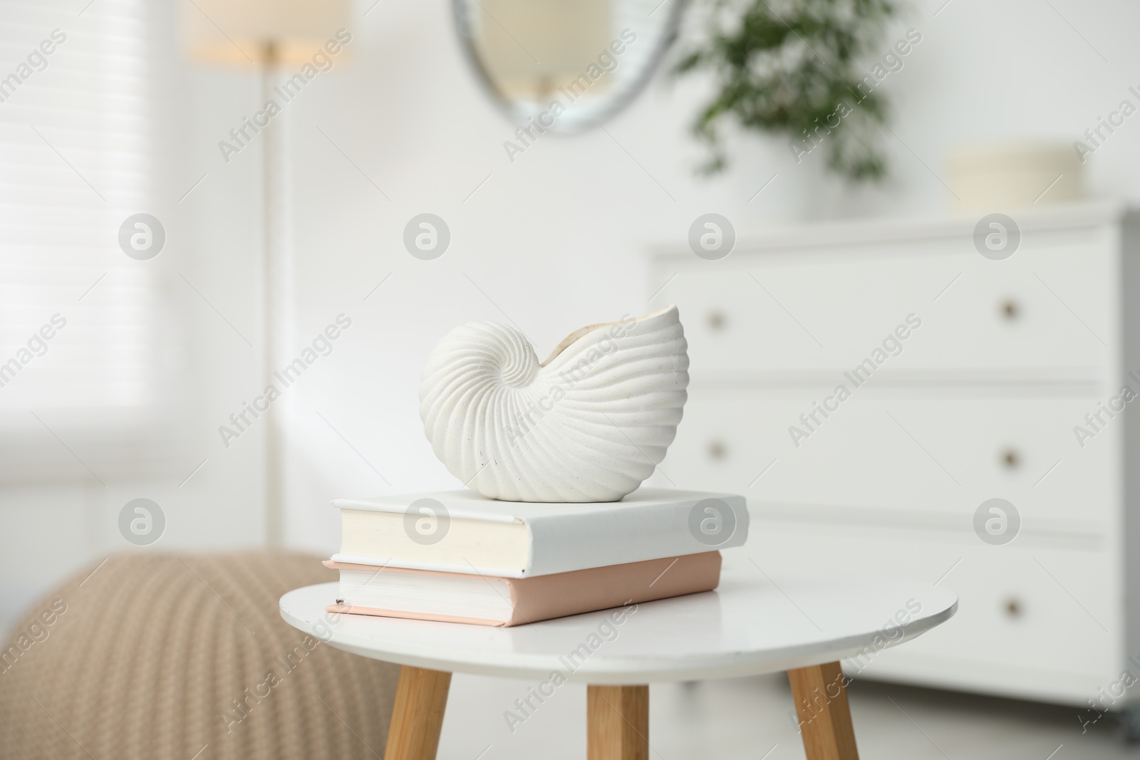Beautiful vase and books on white table indoors, closeup Photo of Beautiful vase and books on white table indoors, closeup