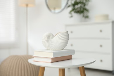Photo of Beautiful vase and books on white table indoors, closeup