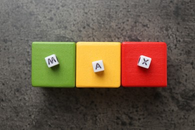 Photo of Word Maximum and colorful cubes on grey table, flat lay