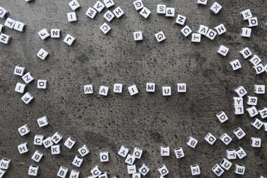Photo of Word Maximum made of cubes on grey table, flat lay