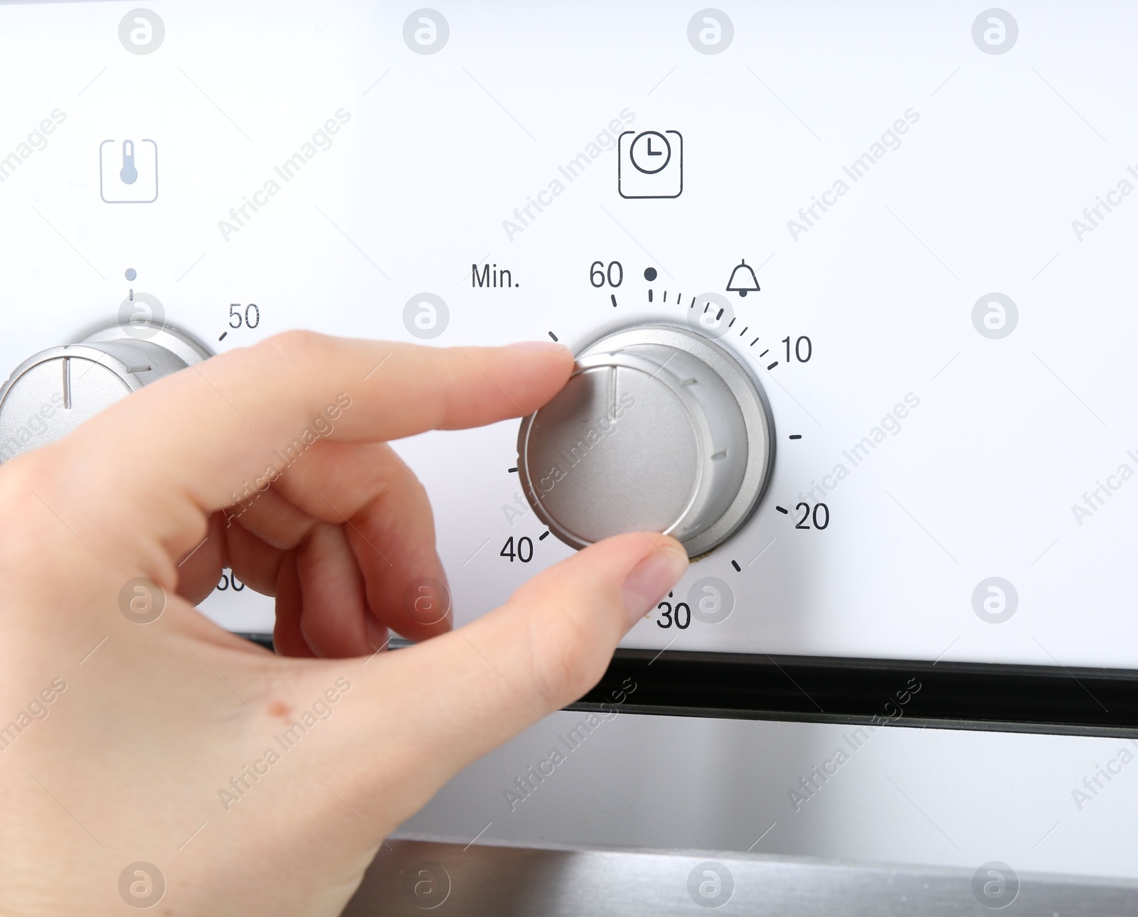 Maximum concept. Woman turning on oven, closeup Photo of Maximum concept. Woman turning on oven, closeup