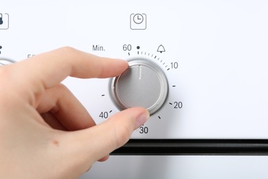 Photo of Maximum concept. Woman turning on oven, closeup