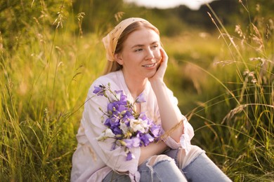 Photo of Beautiful woman with bouquet of wildflowers in meadow