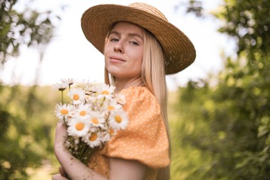 Photo of Beautiful woman with bouquet of wildflowers in forest