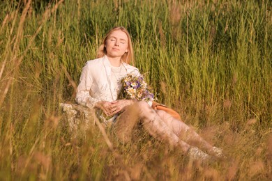 Photo of Woman with bouquet of beautiful wildflowers outdoors on sunny day