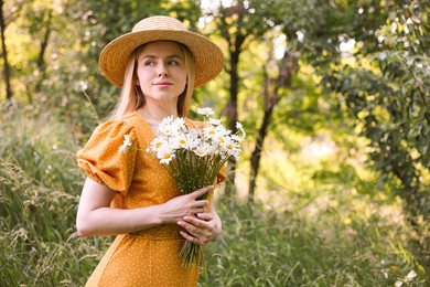 Photo of Beautiful woman with bouquet of wildflowers in forest. Space for text