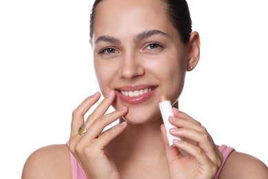 Photo of Young woman with lip balm on white background