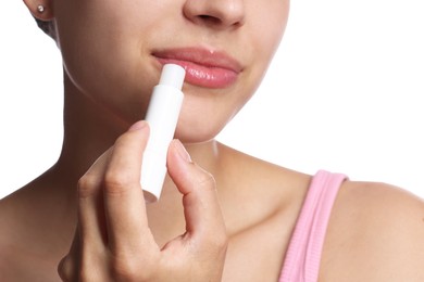 Photo of Young woman with lip balm on white background, closeup