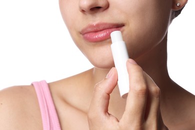 Photo of Young woman with lip balm on white background, closeup