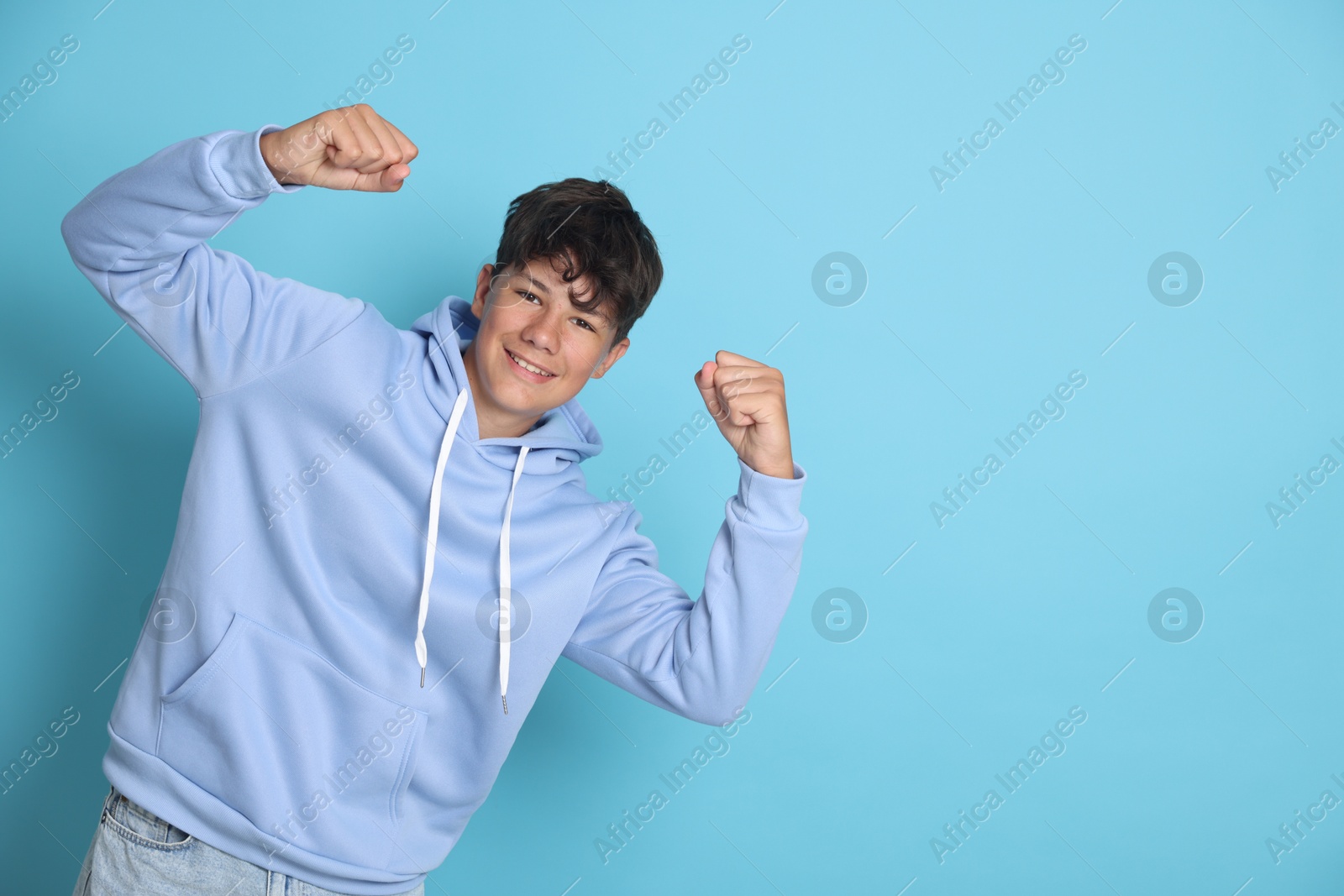 Portrait of teenage boy on light blue background, space for text Photo of Portrait of teenage boy on light blue background, space for text