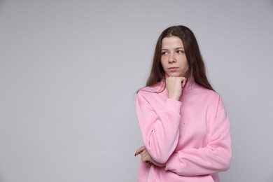 Photo of Portrait of teenage girl on light grey background, space for text
