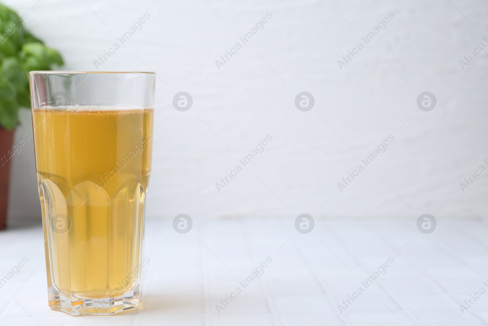 Glass with dirty water on white tiled table, closeup. Space for text Photo of Glass with dirty water on white tiled table, closeup. Space for text
