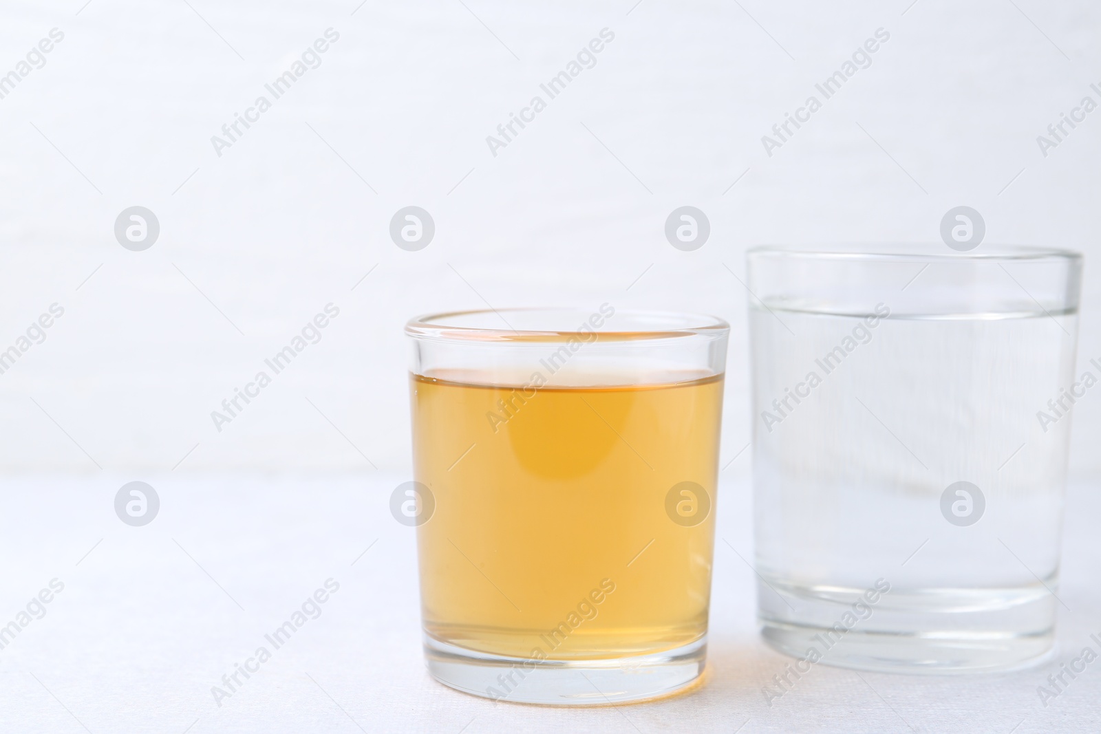 Photo of Glasses with clean and dirty water on light table, closeup. Space for text