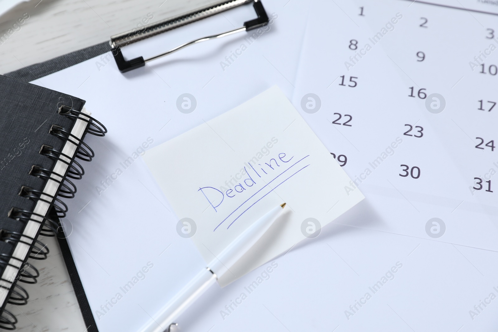 Sticky note with word Deadline, clipboard, calendar, pen and notebook on table, closeup Photo of Sticky note with word Deadline, clipboard, calendar, pen and notebook on table, closeup