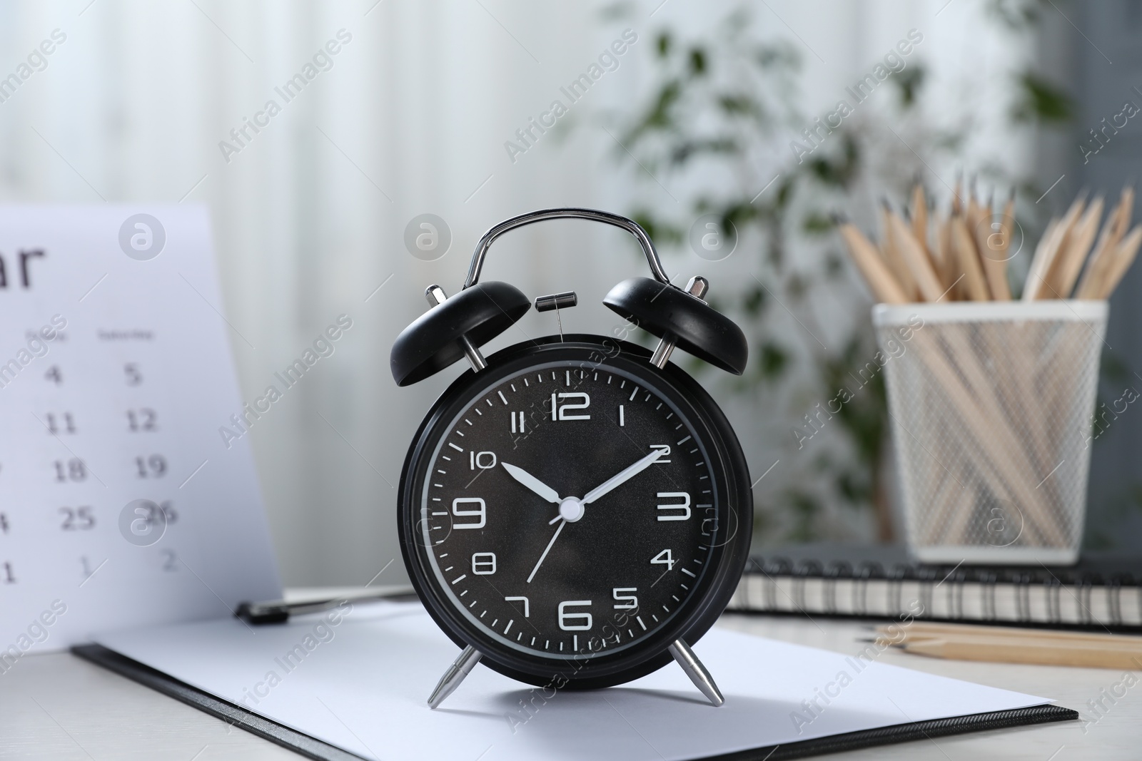 Deadline. Alarm clock, stationery and calendar on table indoors Photo of Deadline. Alarm clock, stationery and calendar on table indoors