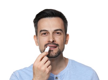 Photo of Handsome man applying lip balm onto his lips on white background