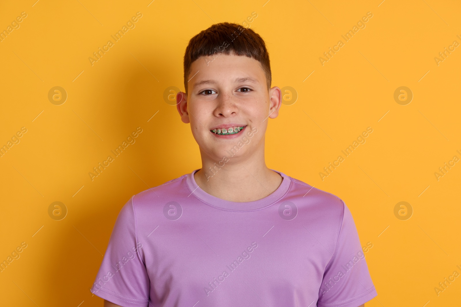 Photo of Portrait of teenage boy on orange background