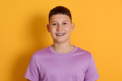 Photo of Portrait of teenage boy on orange background