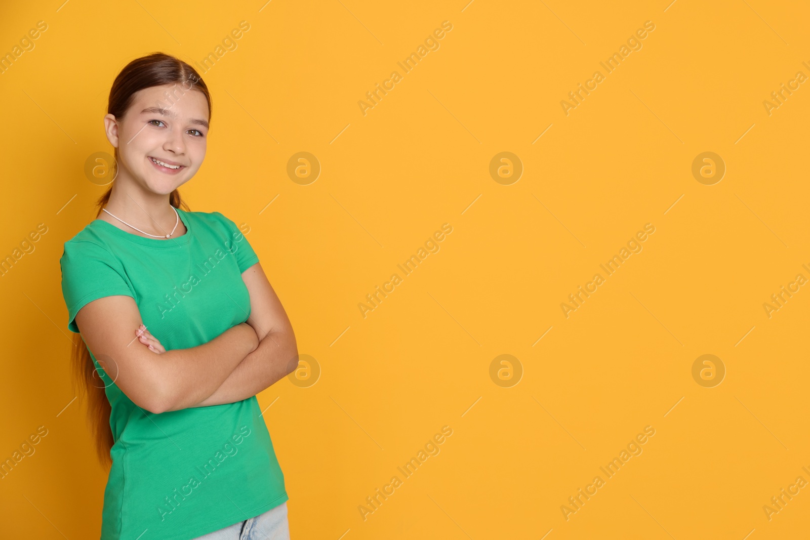 Portrait of teenage girl on orange background, space for text Photo of Portrait of teenage girl on orange background, space for text