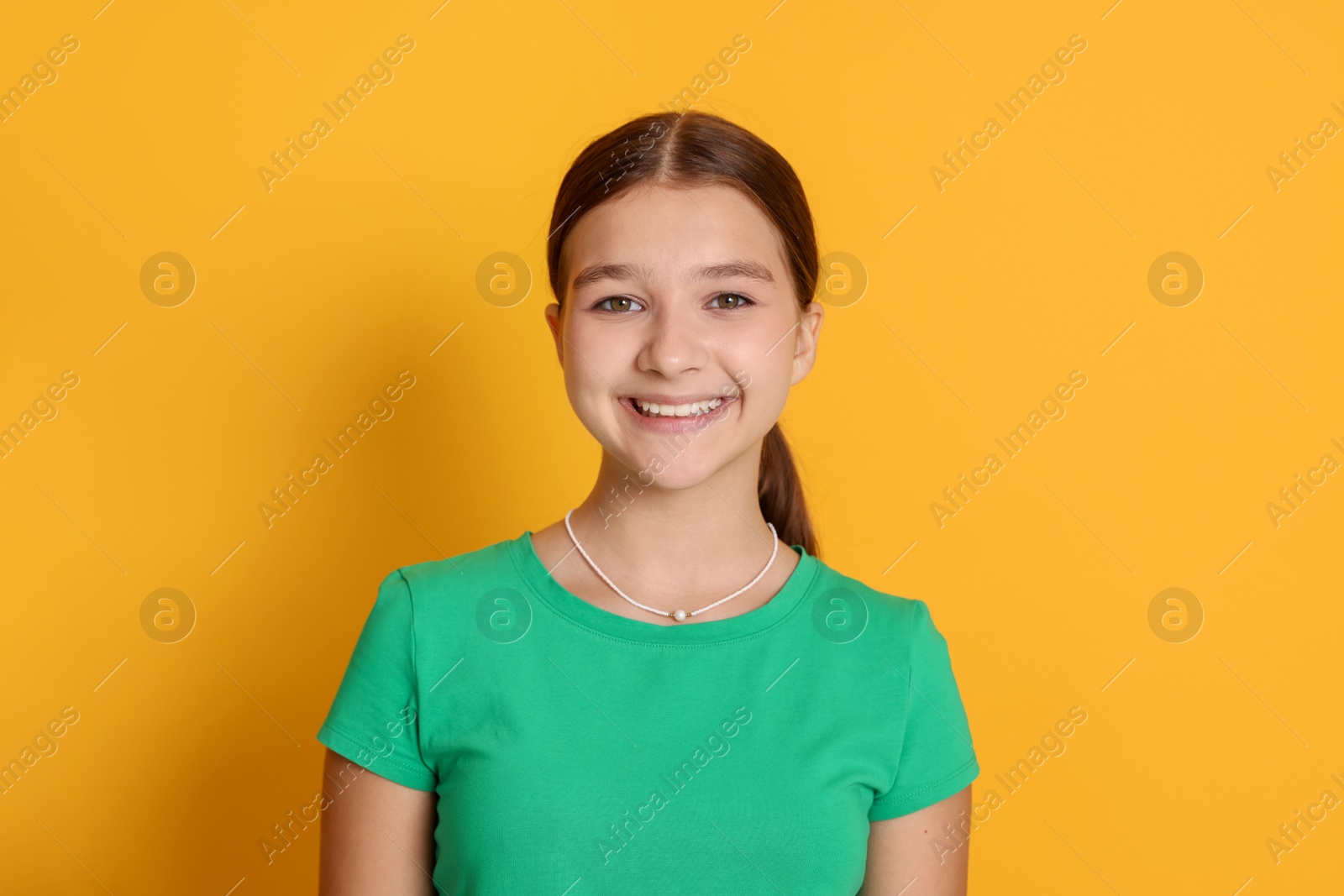 Portrait of teenage girl on orange background Photo of Portrait of teenage girl on orange background
