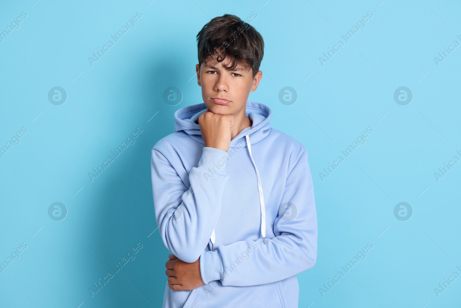 Portrait of teenage boy on light blue background Photo of Portrait of teenage boy on light blue background