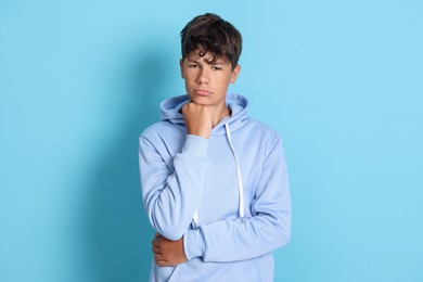 Photo of Portrait of teenage boy on light blue background