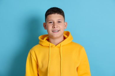 Photo of Portrait of teenage boy on light blue background