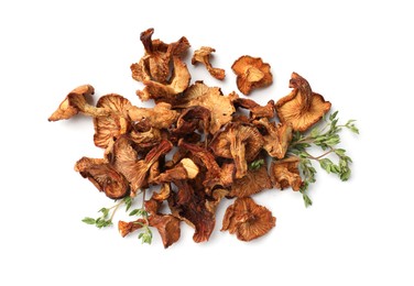 Photo of Dried chanterelle mushrooms and thyme isolated on white, top view