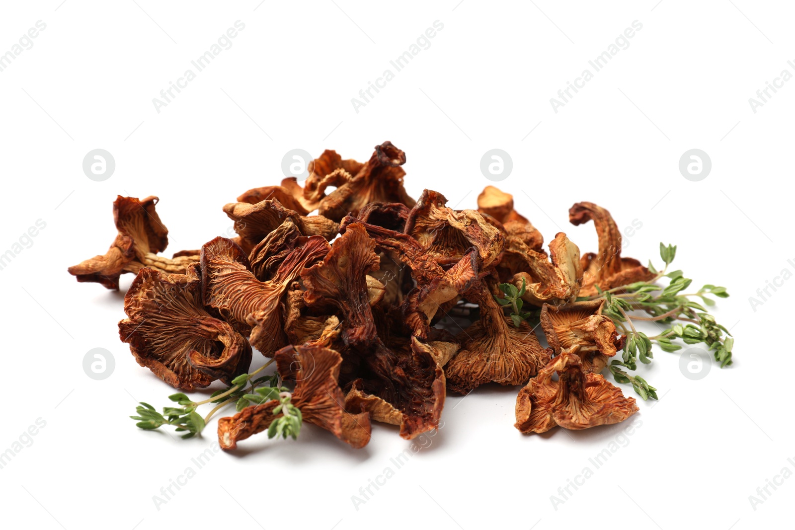 Dried chanterelle mushrooms and thyme isolated on white Photo of Dried chanterelle mushrooms and thyme isolated on white