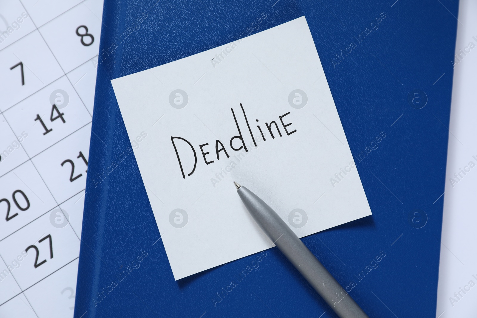 Sticky note with word Deadline, notebook, pen and calendar on table, top view Photo of Sticky note with word Deadline, notebook, pen and calendar on table, top view