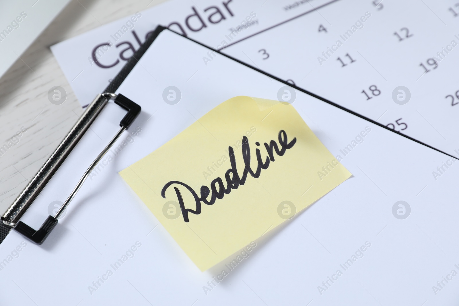 Sticky note with word Deadline, clipboard and calendar on white wooden table, closeup Photo of Sticky note with word Deadline, clipboard and calendar on white wooden table, closeup