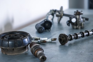 Photo of Different auto parts on grey table indoors, closeup