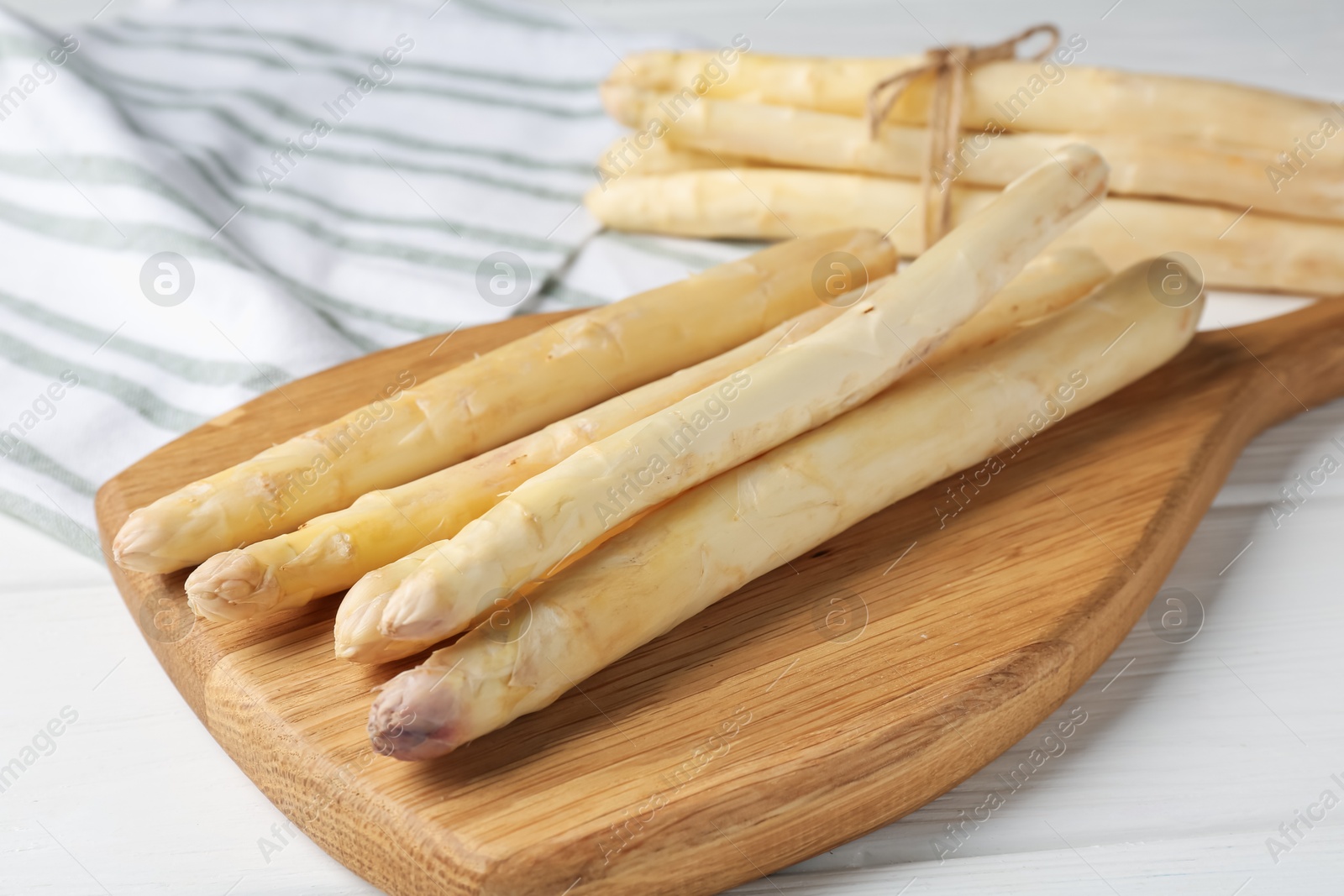 Raw asparagus spears on white wooden table, closeup Photo of Raw asparagus spears on white wooden table, closeup