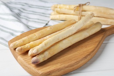 Photo of Raw asparagus spears on white wooden table, closeup